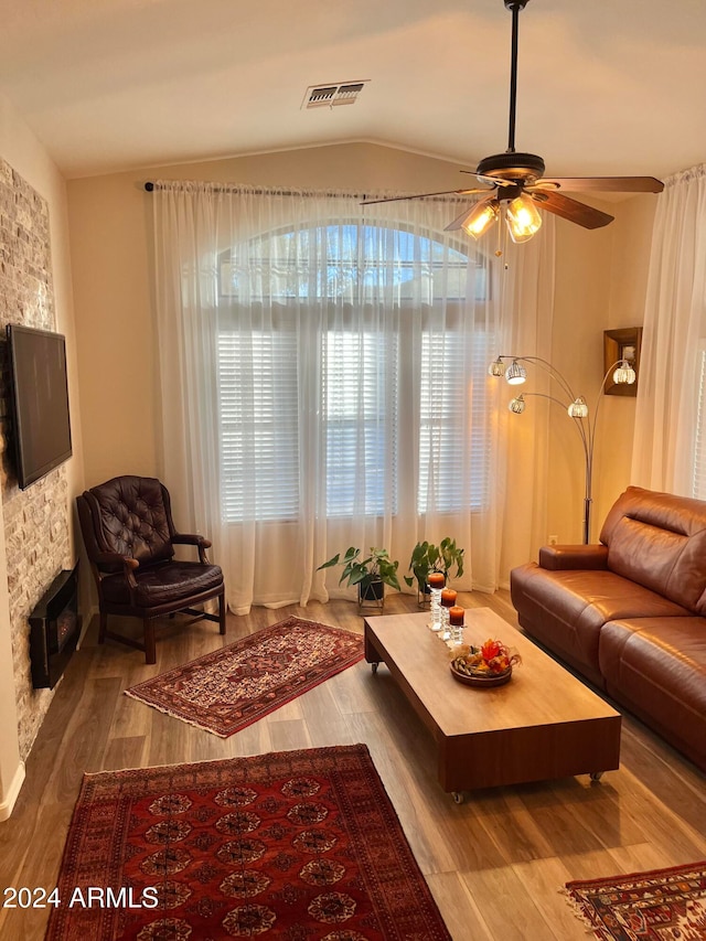 living room with hardwood / wood-style floors, a fireplace, lofted ceiling, and ceiling fan