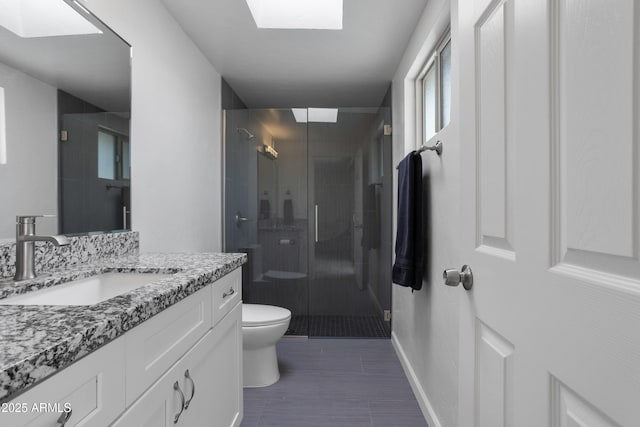 8425 E Hawthorne St, Tucson, AZ 85710 - bathroom with a skylight, toilet, a stall shower, vanity, and baseboards
