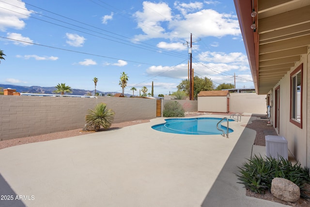 8425 E Hawthorne St, Tucson, AZ 85710 - view of swimming pool featuring a patio area, a fenced backyard, a shed, an outbuilding, and a mountain view