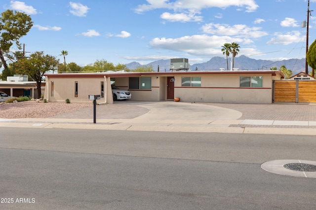 8425 E Hawthorne St, Tucson, AZ 85710 - ranch-style home with a mountain view, decorative driveway, an attached carport, and fence