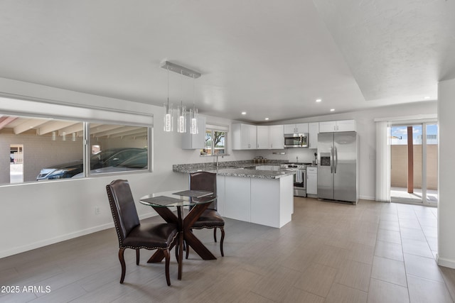 8425 E Hawthorne St, Tucson, AZ 85710 - kitchen with appliances with stainless steel finishes, a peninsula, recessed lighting, stone countertops, and white cabinets