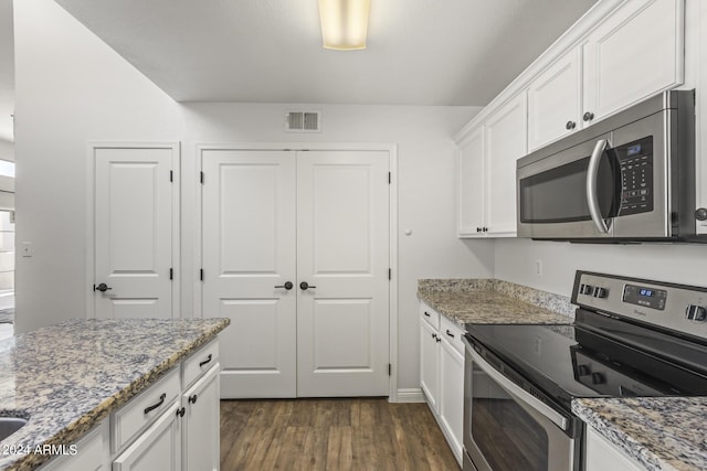 kitchen with white cabinets, stainless steel appliances, dark wood-style flooring, visible vents, and light stone counters