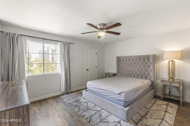 bedroom featuring wood finished floors, a ceiling fan, and baseboards