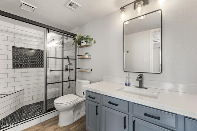 full bathroom with a shower stall, wood finished floors, visible vents, and toilet