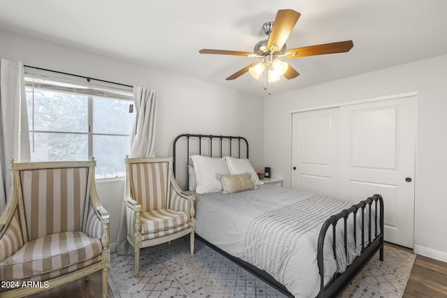 bedroom featuring ceiling fan, baseboards, wood finished floors, and a closet