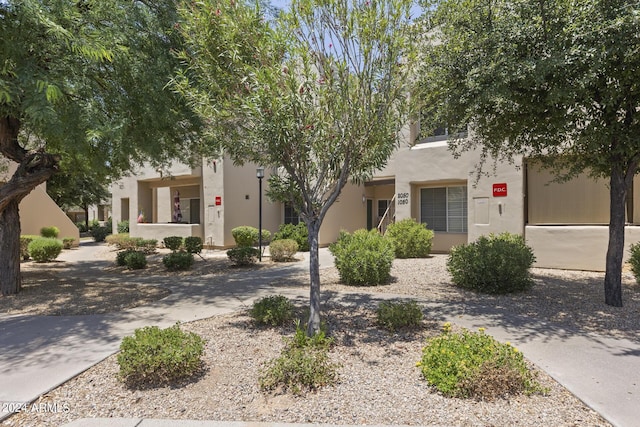 pueblo-style house featuring concrete driveway and stucco siding