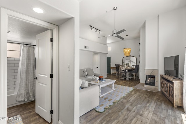 living room with visible vents, wood finished floors, and ceiling fan