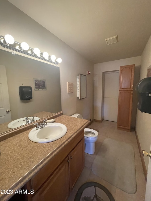 bathroom featuring tile patterned flooring, vanity, and toilet