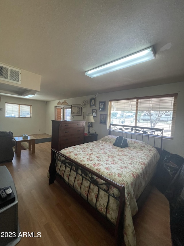 bedroom featuring wood-type flooring and a textured ceiling