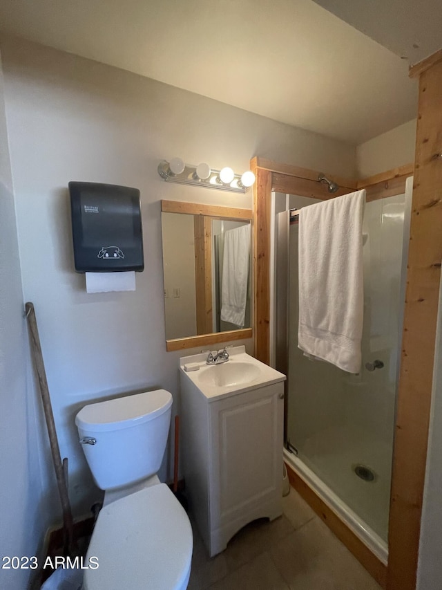 bathroom featuring vanity, tile patterned floors, toilet, and walk in shower