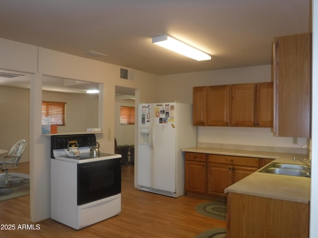 kitchen featuring sink, electric range, white refrigerator with ice dispenser, and light wood-type flooring