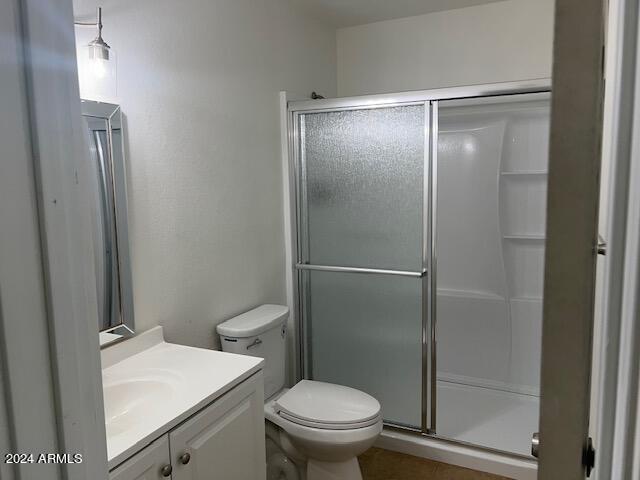 bathroom featuring vanity, toilet, and an enclosed shower