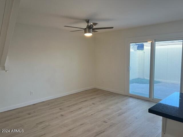 unfurnished room with light wood-type flooring and ceiling fan