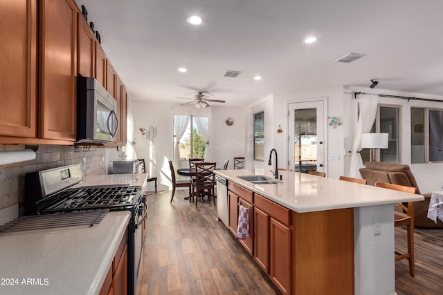 kitchen with a center island with sink, sink, a barn door, and stainless steel appliances