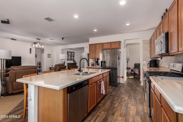 kitchen featuring a center island with sink, appliances with stainless steel finishes, sink, a breakfast bar, and dark hardwood / wood-style floors