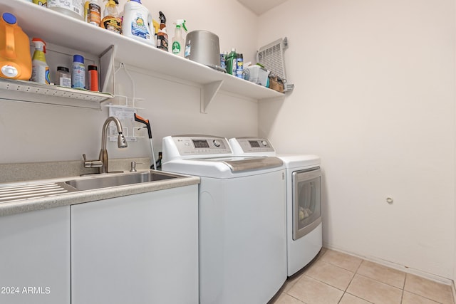 laundry area with sink, washer and dryer, and light tile patterned flooring