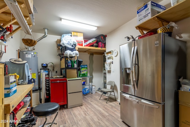 kitchen with light hardwood / wood-style floors, stainless steel refrigerator with ice dispenser, a textured ceiling, and gas water heater