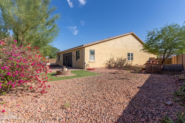 back of property featuring an outdoor fire pit and a patio area