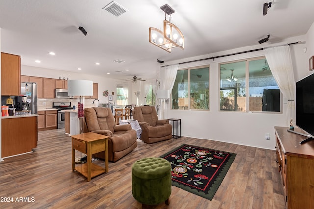 living room featuring hardwood / wood-style floors and ceiling fan with notable chandelier