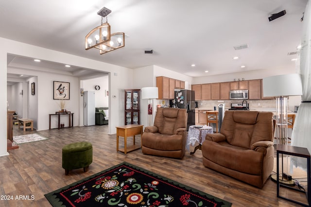 living room with a notable chandelier and dark wood-type flooring