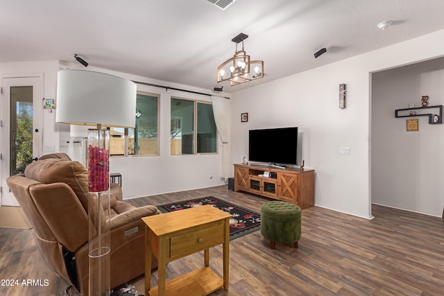 living room featuring a wealth of natural light, hardwood / wood-style floors, and an inviting chandelier