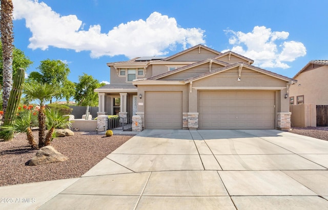 view of front of property featuring driveway, solar panels, stone siding, an attached garage, and fence