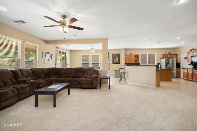 living room featuring recessed lighting, visible vents, a ceiling fan, and light colored carpet