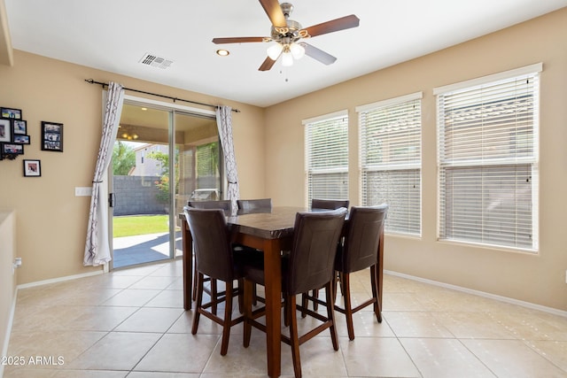 dining space with baseboards, visible vents, a ceiling fan, and light tile patterned flooring