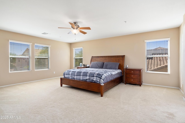 bedroom with a ceiling fan, light colored carpet, visible vents, and baseboards