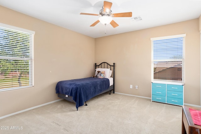 bedroom featuring baseboards, visible vents, a ceiling fan, and light colored carpet