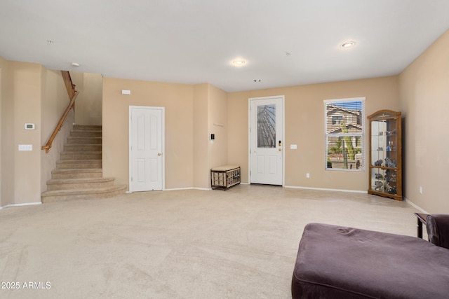 living area with recessed lighting, light carpet, baseboards, and stairs