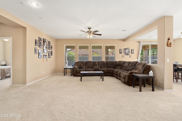 living room with light carpet, ceiling fan, and baseboards