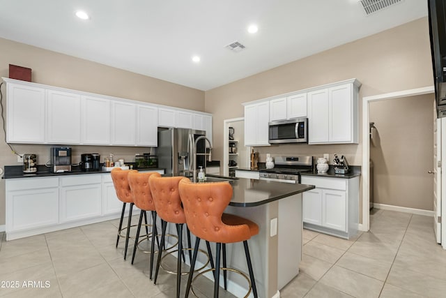 kitchen with white cabinetry, a kitchen island with sink, and appliances with stainless steel finishes