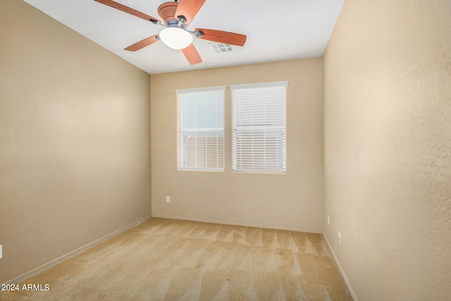 carpeted spare room with ceiling fan