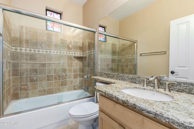 full bathroom with tile patterned floors, shower / bath combination with glass door, vanity, and toilet