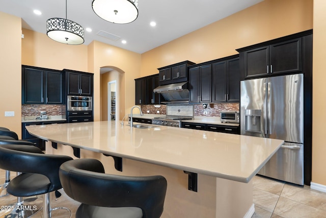 2285 E Mead Dr, Gilbert, AZ 85298 - kitchen featuring stainless steel appliances, arched walkways, a sink, dark cabinetry, and recessed lighting