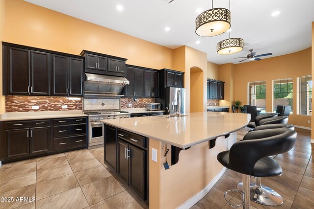 2285 E Mead Dr, Gilbert, AZ 85298 - kitchen with appliances with stainless steel finishes, a ceiling fan, light countertops, backsplash, and under cabinet range hood
