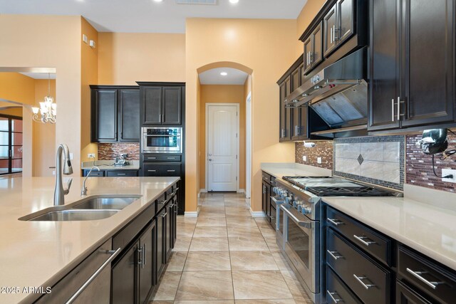 2285 E Mead Dr, Gilbert, AZ 85298 - kitchen with stainless steel appliances, a sink, arched walkways, under cabinet range hood, and decorative backsplash