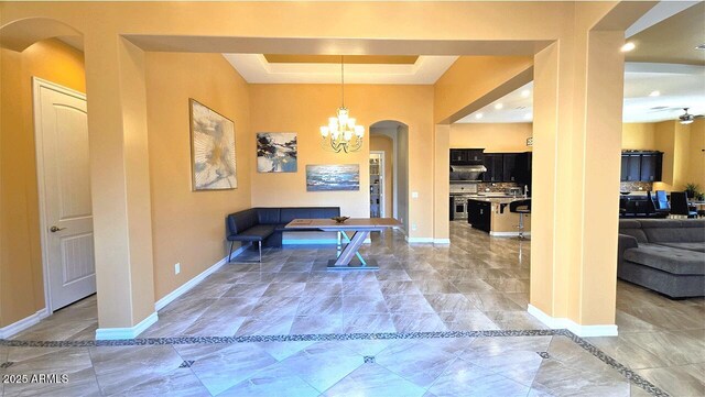 2285 E Mead Dr, Gilbert, AZ 85298 - dining room with arched walkways, a chandelier, a raised ceiling, and baseboards