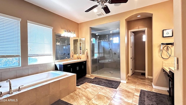 bathroom featuring plus walk in shower, vanity, and ceiling fan