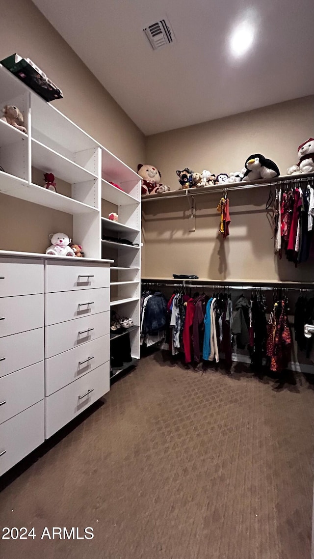 walk in closet with dark colored carpet