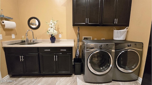 laundry room with washing machine and clothes dryer, sink, and cabinets