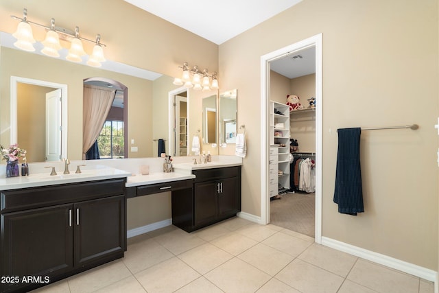 bathroom featuring vanity, baseboards, a spacious closet, tile patterned flooring, and visible vents