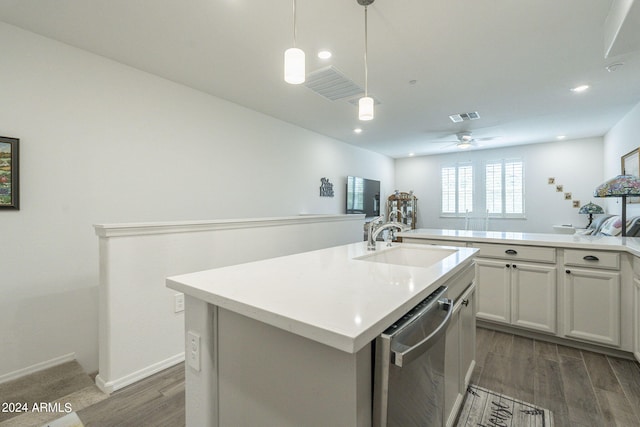 kitchen with an island with sink, stainless steel dishwasher, sink, and dark hardwood / wood-style floors