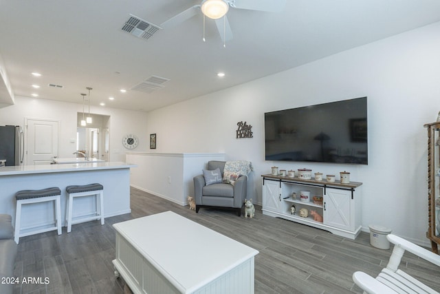 living room featuring dark hardwood / wood-style flooring, sink, and ceiling fan