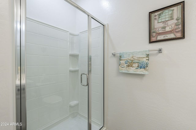 bathroom featuring a shower with shower door