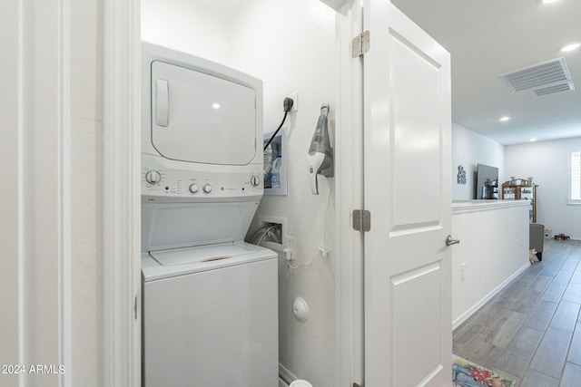 washroom featuring stacked washer and dryer and light hardwood / wood-style floors