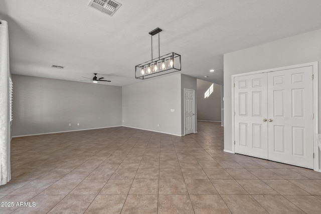 unfurnished room featuring light tile patterned floors, visible vents, baseboards, and ceiling fan