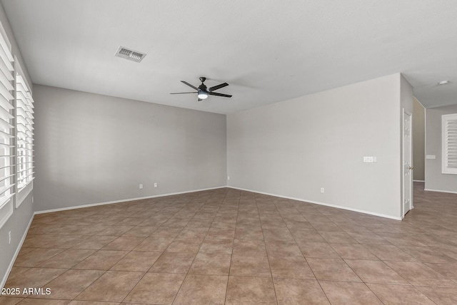 empty room with light tile patterned floors, baseboards, visible vents, and ceiling fan