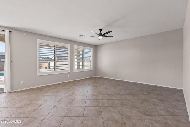 spare room with light tile patterned floors, a ceiling fan, visible vents, and baseboards